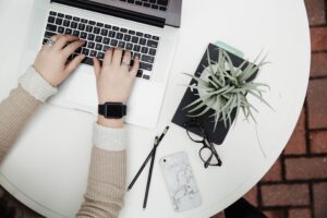 Person schreibt auf ihrem Laptop